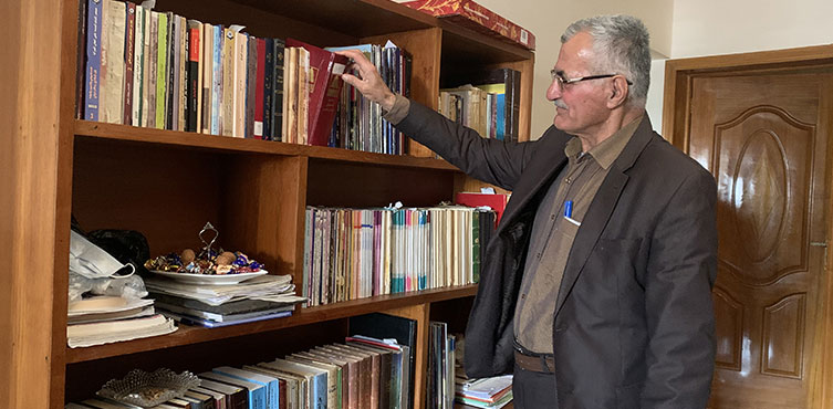 Mann steht vor einen Bücherregal