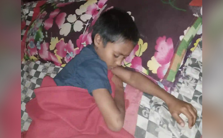 Ein Junge liegt in einem Bett