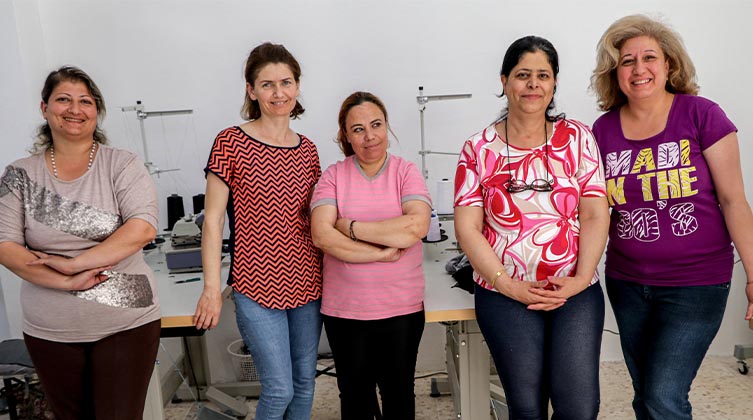 Fünf Frauen stehen in einem Raum