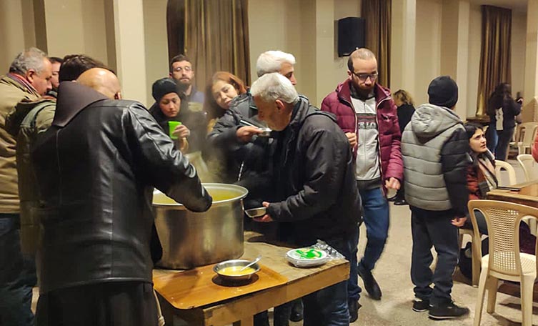 Menschen wird in einer Kirche in Latakia Suppe ausgeschöpft