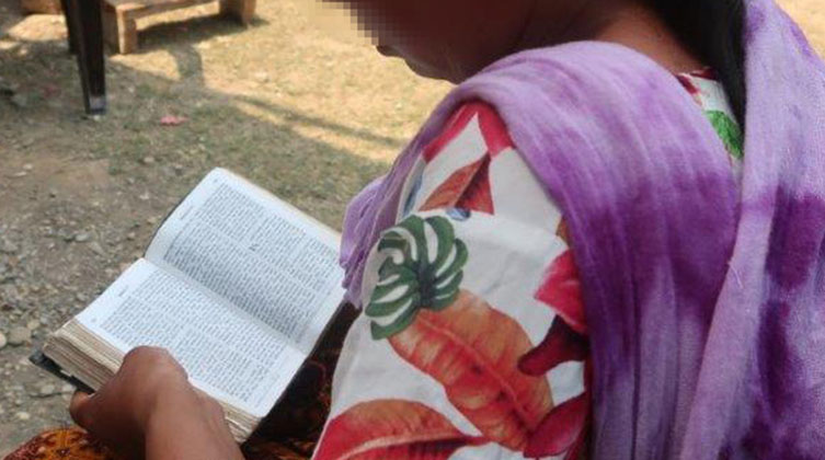 Eine Frau seitlich hält eine Bibel in den Händen