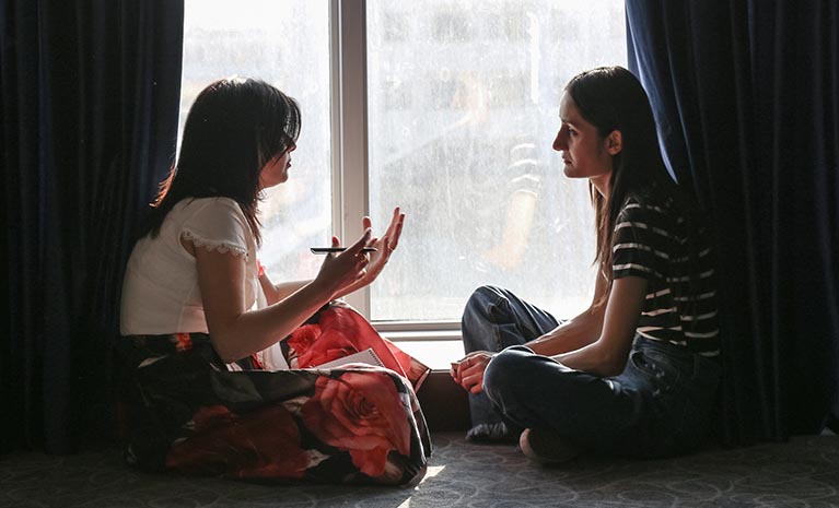 Zwei Frauen sitzen auf dem Boden und reden