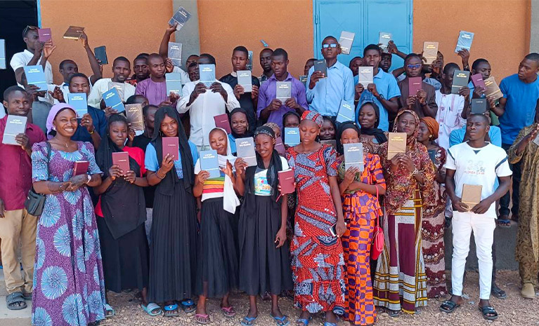 Eine Gruppe junger afrikanischer Menschen präsentiert ihre Bibeln