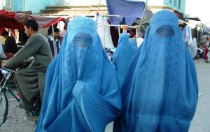 Afghanistan: Zwei Frauen verschleiert mit hellblauen Burkas, dahinter eine Fahrradfahrer