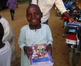 Nigeria: ein Kind aus der Ortschaft Gani mit einer Open Doors-Kinderbibel/Open Doors