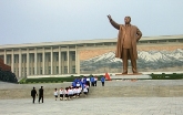 Monumentale Statue von Kim Il-Sung. Pioniere legen Blumen nieder.