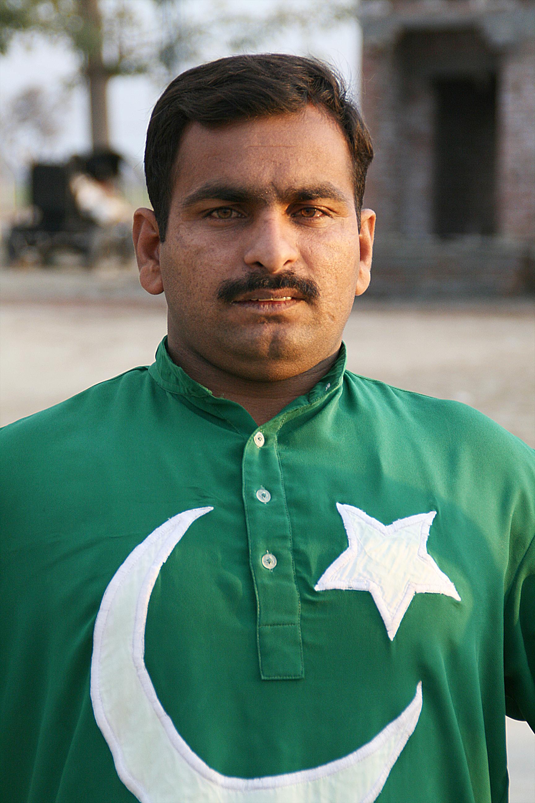 Pakistan: ein Mann trägt ein Hemd in den Farben der Landesflagge