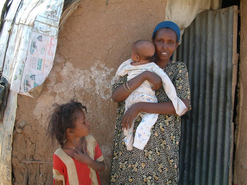 Somalia: eine Frau vor ihrer Hütte mit einem Kind