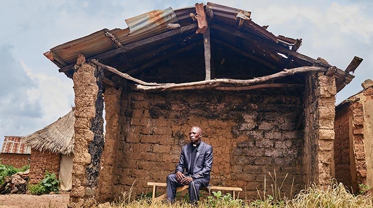 Ein Pastor sitzt in den Trümmern einer zerstörten Kirche.