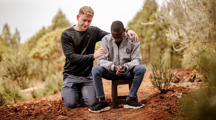 Ein junger Mann betet für einen Christen am Horn von Afrika
