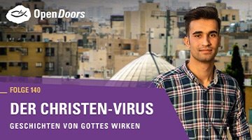Junger Mann mit kariertem Hemd vor einer Stadt im Nahen Osten.