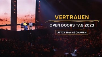 Ein Mann und eine Frau werden auf einer großen Bühne interviewt, davor ein zahlreiches Publikum