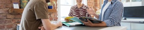 Mitarbeitende besprechen ein Materialpaket