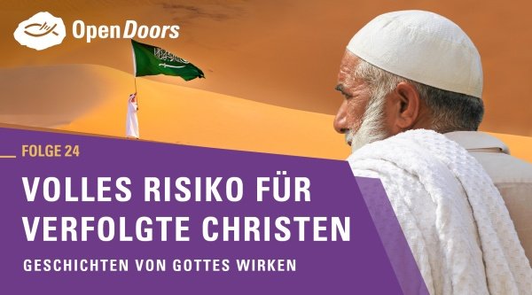 Mann schaut in die Ferne ein anderer Mann schwingt die saudi-arabische Flagge und Sandwüste im Hintergrund