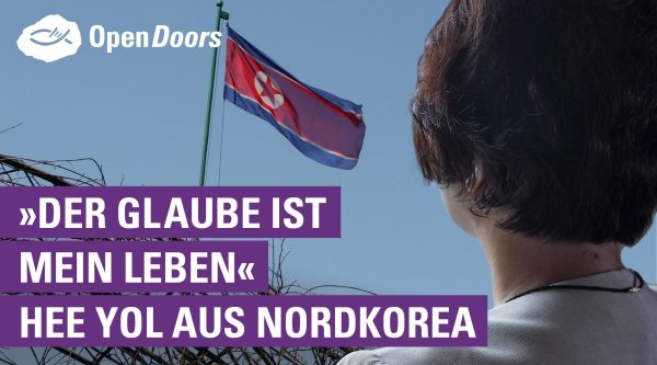 Hee Yol aus Nordkorea blickt auf die nordkoreanische Flagge
