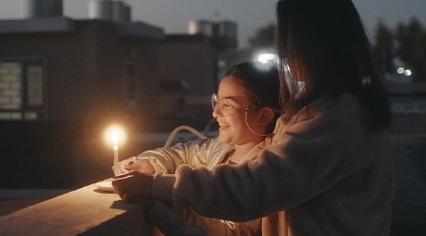Rafif und ihre Mutter freuen sich am Licht einer Kerze