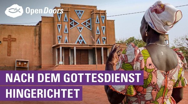Eine afrikanische Frau steht vor einer Kirche