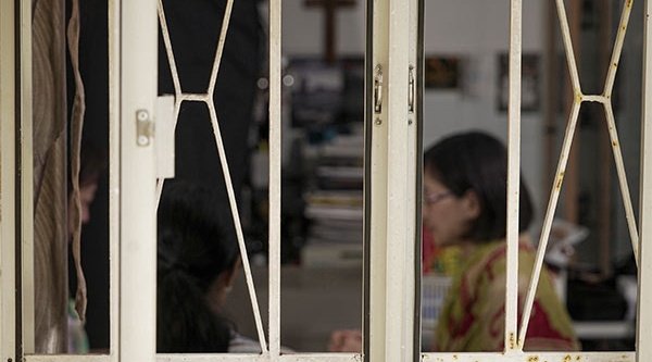 Chinesische Christen an einem Tisch hinter Fenstern
