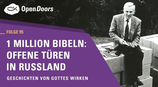 Mann sitzt auf einer Mauer und hat viele Bücher bei sich