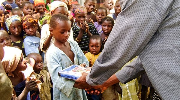 Ein nigerianischer Junge erhält ein Kinderbibel von Open Doors