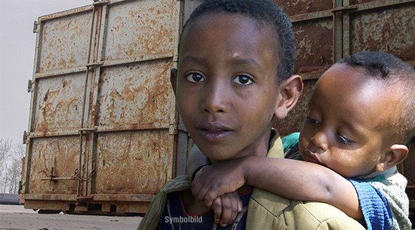 Afrikanisches Kind trägt Baby auf dem Rücken