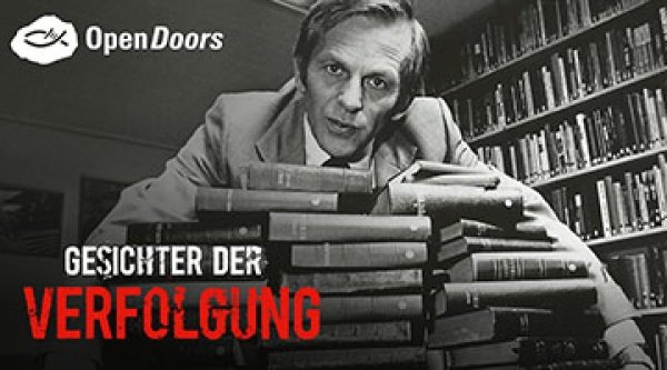 Bruder Andrew beugt sich über viele Bibeln 