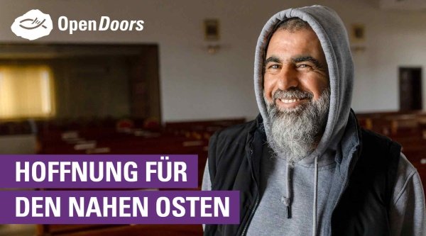 Ein Mann steht in einem Raum und lächelt