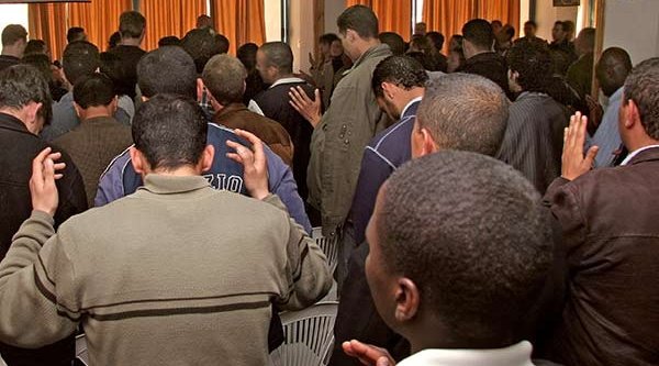 Ein Raum voller Menschen im Gebet (Symbolbild)