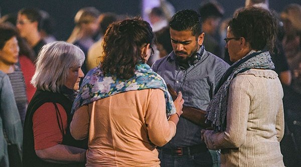 Menschen stehen in kleinen Gruppen im Gebet für verfolgte Christen zusammen