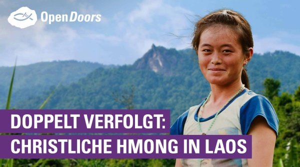 Eine Frau steht vor mehreren Bergen und Wäldern im Hintergrund