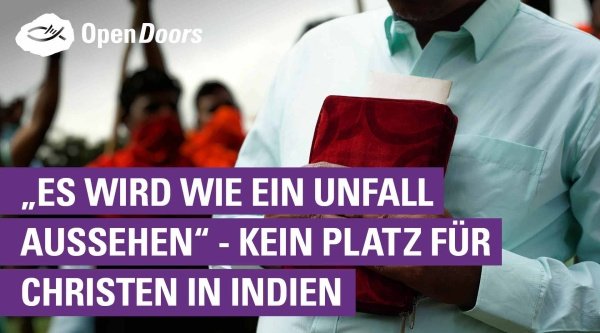 Ein Mann steht mit einer Bibel in seiner Hand im Vordergrund