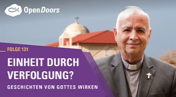 Pfarrer mit weißen Haaren im Vordergrund einer Kirche 