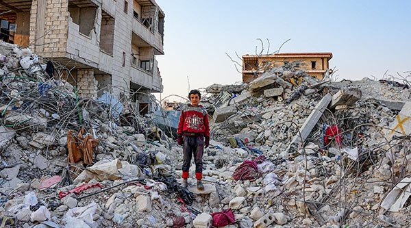 Syrisches Kind steht auf dem Schutt eines eingestürzten Hauses