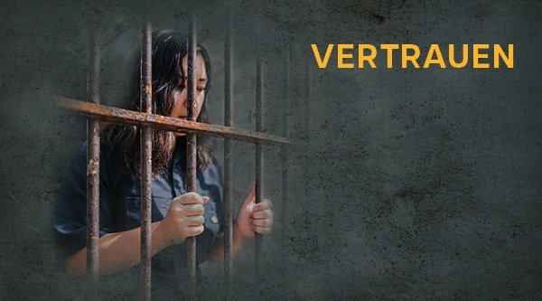 Eine asiatische Frau hält sich an Gitterstäben fest und schaut traurig nach unten. Open Doors Tag - Vertrauen