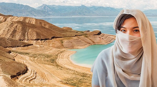 Brünette Frau mit dunklen Augen in weißem Schleier, im Hintergrund Berge und Meer 