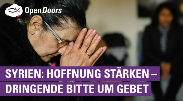 Frau betet mit gefalteten Händen