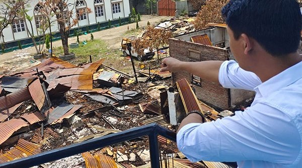 Ein Christ blickt auf die Überreste seines Hauses und seines Büros