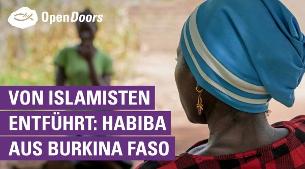 Habiba von hinten mit blauem Kopftuch und kariertem Oberteil