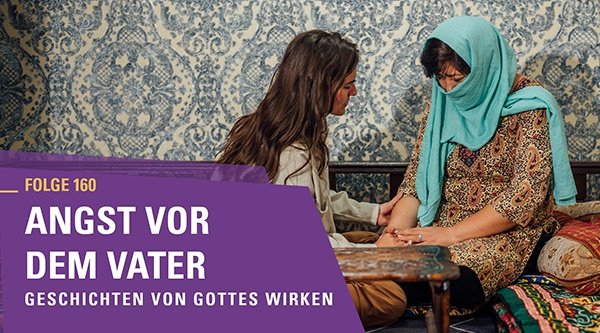 Zwei Frauen beten miteinander, eine ist verschleiert und in einem typischen Raum mit gemusterter Tapete aus Zentralasien