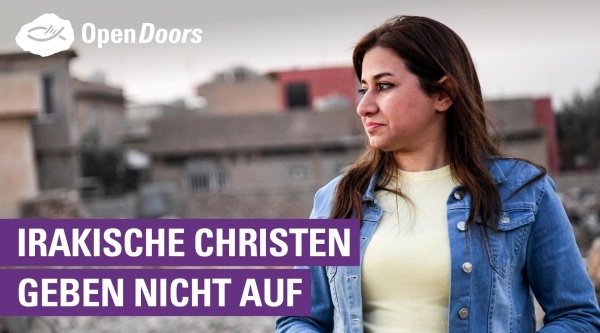 Eine Frau mit gelben T-shirt und Jeansjacke sieht resigniert zur Seite, im Hintergrund kleine Häuser