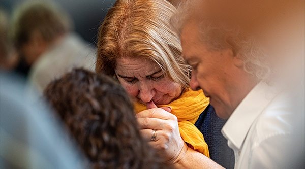 Eine Frau und ein Mann beten in einer Gebetsgruppe für verfolgte Christen