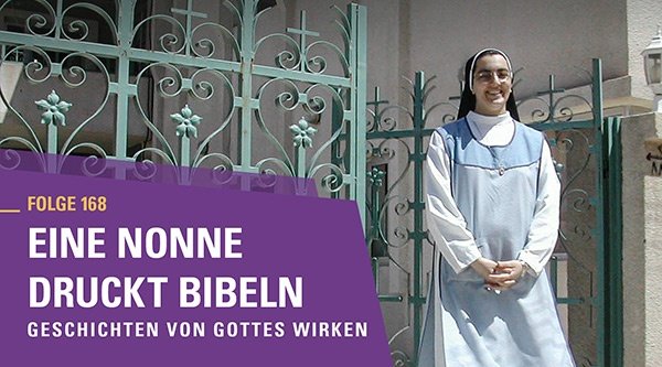 Eine Nonne steht lächelnd vor einem Tor.