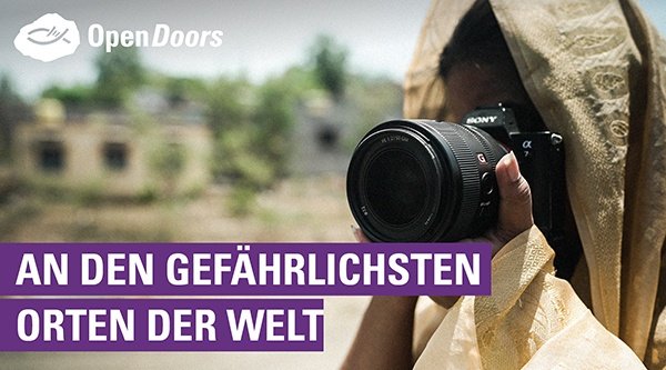 Eine Person schaut durch den Sucher einer Kamera