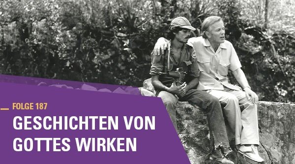 Zwei Männer sitzen freundschaftlich auf einer Mauer