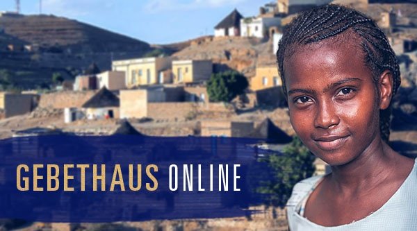 Eine Christin aus Eritrea steht vor ihrem Dorf