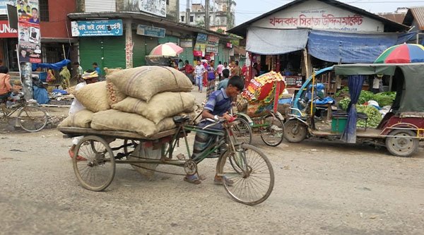 Ein Mann in Bangladesch schiebt sein Lastenfahrrad in der Hauptstadt Dhaka