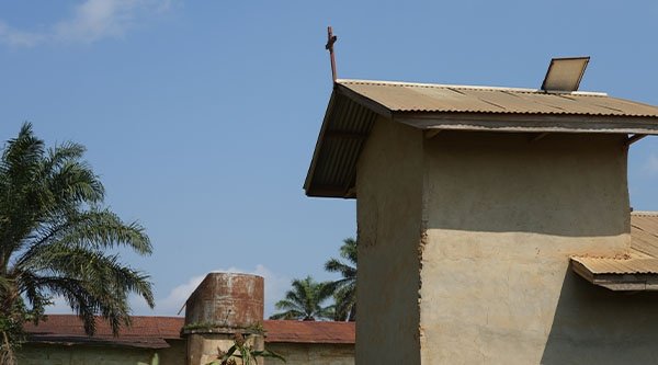 Ein kleines Haus mit einem Kreuz auf dem Dach
