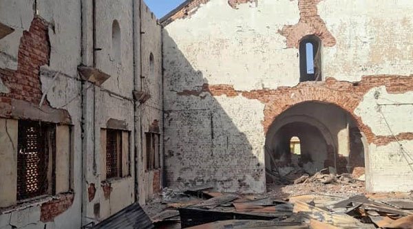 Ein zerstörtes Kirchengebäude im Sudan ohne Dach. Auf dem Boden liegen Trümmerteile. Die Sonne scheint in auf die Überreste der Kirche.