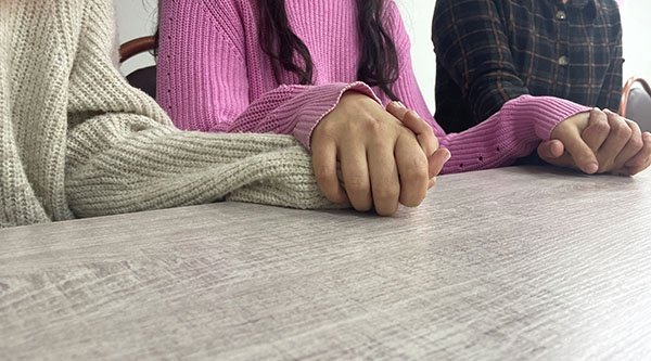 Drei Personen fassen sich an den Händen