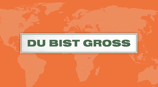 Auf einem orangenen Hintergrund steht ein Schild mit dem Titel in grün: Du bist groß